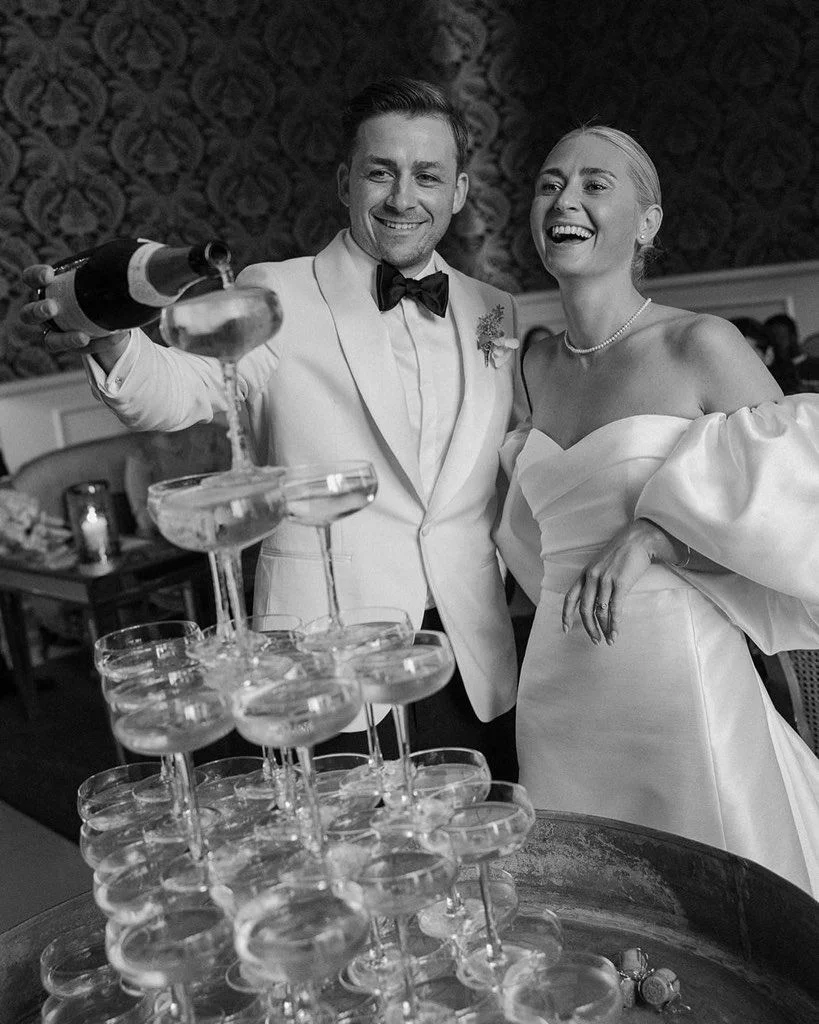 Et brudepar hælder champagne i et champagnetårn